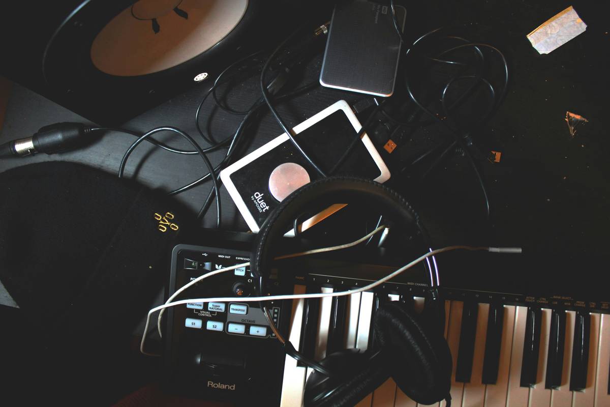 equipment for podcast beginners setup on a desk with mic, interface, and headphones